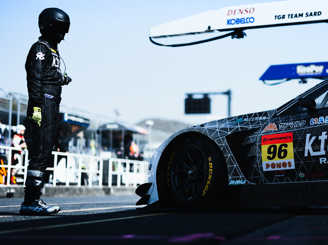 レース場でドライバーと車が写っている写真